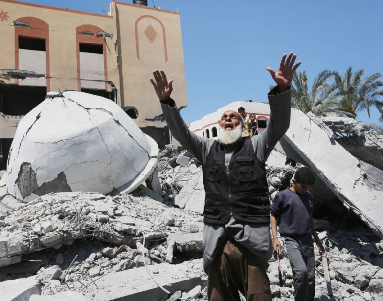 Um homem palestino reage perto dos escombros da mesquita Abu Bakr al-Siddiq e edifícios vizinhos em Deir Balah após um ataque israelense na Faixa de Gaza em 13 de abril de 2024. (Ashraf Amra / Anadolu via Getty Images)