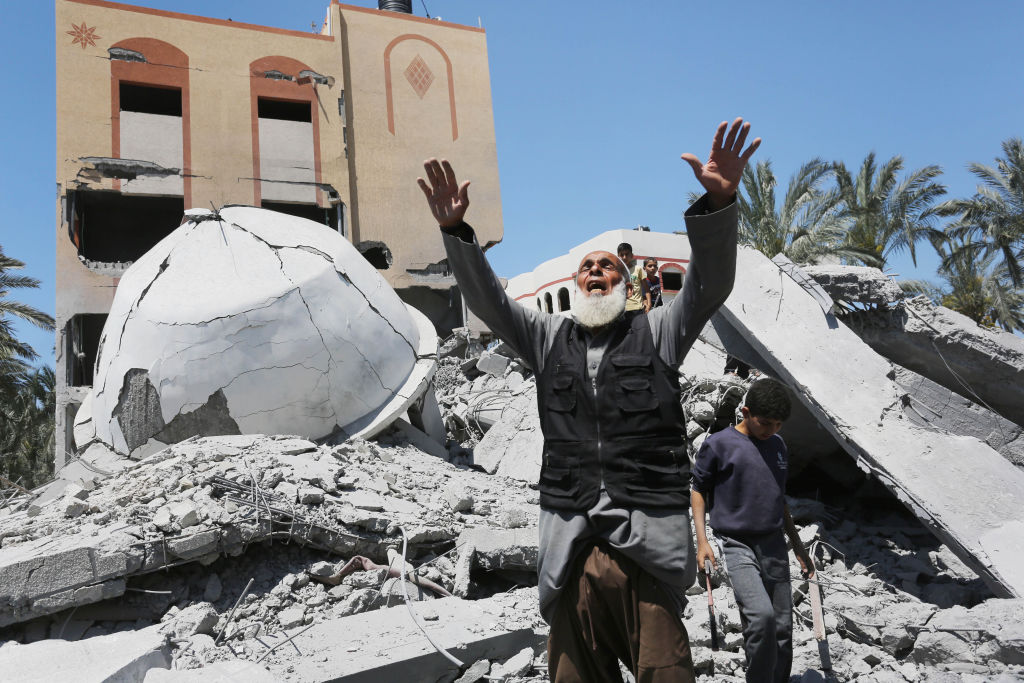 Um homem palestino reage perto dos escombros da mesquita Abu Bakr al-Siddiq e edifícios vizinhos em Deir Balah após um ataque israelense na Faixa de Gaza em 13 de abril de 2024. (Ashraf Amra / Anadolu via Getty Images)