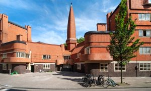 O mais prolífico dos edifícios da Escola de Amsterdam, Het Schip (O Barco) foi desenhado por Michael de Klerk em 1919 como um produto da Lei da Moradia de 1901, que favorecia a criação de associações cooperativas de moradia.