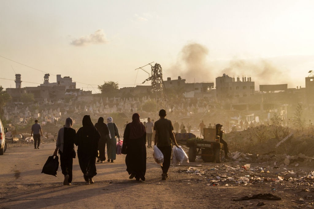 Palestinos caminham por uma rua bombardeada na Cidade de Gaza em 17 de outubro de 2024. (Mahmoud Issa / SOPA Images / LightRocket via Getty Images)