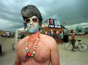 Um participante do Burning Man, de Las Vegas, exibe um sorriso sarcástico usando uma fantasia de Elvis Presley em 6 de setembro de 1998, no Deserto de Black Rock, Nevada. (Mike Nelson / AFP via Getty Images)