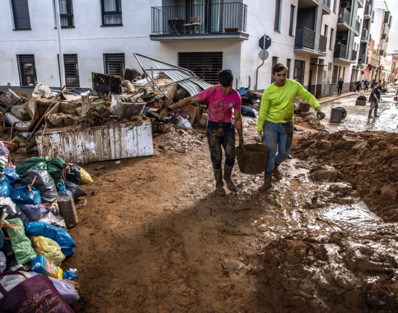 Moradores limpam escombros de enchentes após enchentes extremas em Paiporta, Espanha, em 3 de novembro de 2024. (Angel Garcia / Bloomberg via Getty Images)