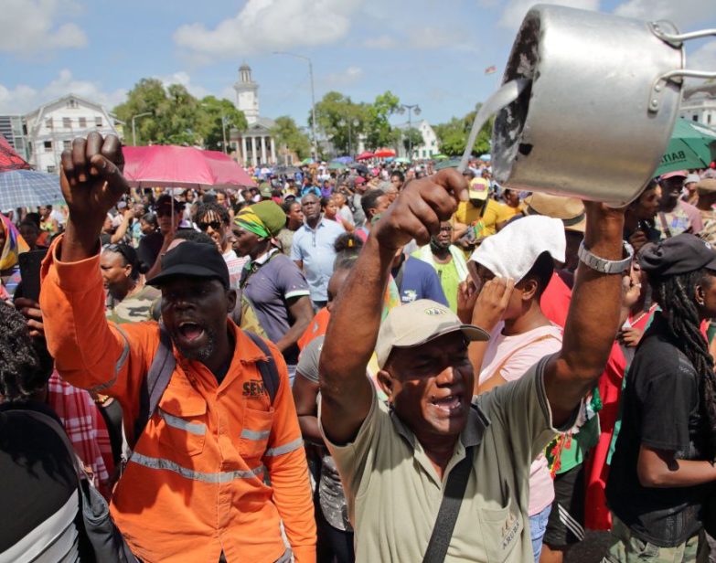 Um manifestante bate em uma panela durante um protesto contra as políticas econômicas do governo em Paramaribo, Suriname, em 17 de fevereiro de 2023. (Ranu Abhelakh / AFP via Getty Images)