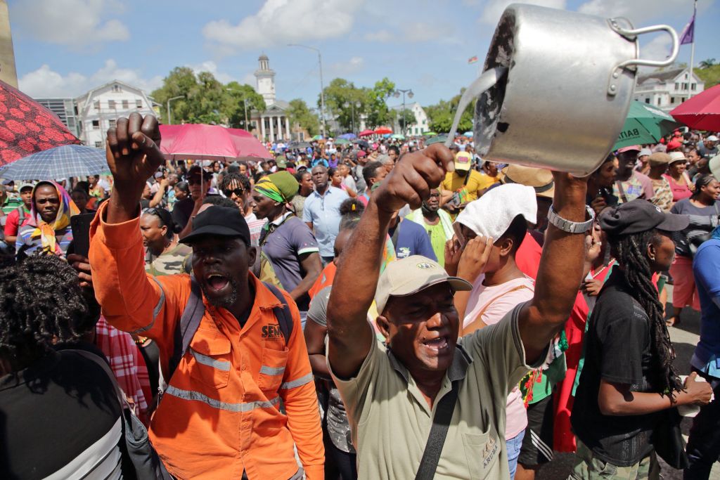 Um manifestante bate em uma panela durante um protesto contra as políticas econômicas do governo em Paramaribo, Suriname, em 17 de fevereiro de 2023. (Ranu Abhelakh / AFP via Getty Images)